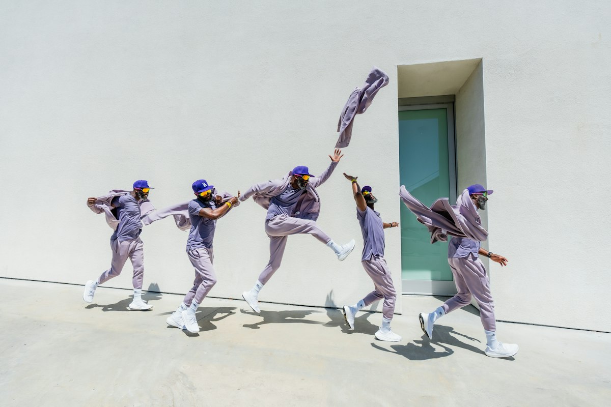 白い壁の前でジャンプしながら踊るグループ
